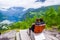 Male tourists sitting on the Queen Sony Chair at the Flydalsjuvet Viewpoint. The Geiranger village and Geirangerfjord landscape.