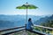 Male tourists Sitting on wooden balcony Which has a large umbrella shading the sun,