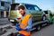 Male tow truck operator checking electronic invoice