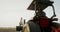 A male tractor driver drives an agricultural tractor plowing a small field