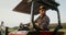 A male tractor driver drives an agricultural tractor plowing a small field