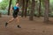 Male trail runner jumping in the forest