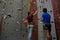 Male trainer guiding woman in climbing wall at club