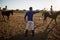 Male trainer guiding young women in riding horse