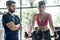 The male trainer helps to take care and teach the right exercise for beautiful women in the modern gym