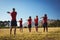 Male trainer instructing kids while exercising in the boot camp