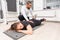 Male trainer stretching calf of woman in gym