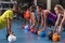 Male trainer training women to perform exercise with kettlebell