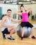 Male trainer with woman doing crunches on the ball