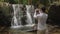 Male traveler is filming waterfall by smartphone