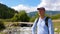 Male traveler looking sideway while standing in landscape with bridge over river