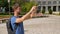 Male traveller taking panorama picture of cityscape on gadget, summer vacation