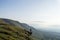 A male trekker standing on the edge of a cliff. Looking out on the hills of the Brecon Beacons, Wales, UK on a summers afternoon.