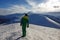 Male trekker standing on a top of the mountain while observing the horizon