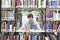 Male University Student Amid Books In Library