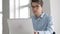 Male university student looking at laptop screen thoughtfully while doing homework. Closeup of concentrated boy trying