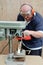 Male using a drill press on wood