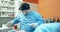 Male veterinarian, in surgical outfit, prepares surgical and electronical tools to start surgery on dog At the