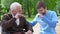 Male volunteer and elderly disabled man laughing in park, lonely pensioners care
