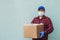 Male volunteer wearing a protective mask with a box of groceries, charity