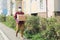 A male volunteer wearing a protective mask walks down the street with a box of groceries, charity