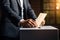 A male voter in a business suit places a ballot in the ballot box. The concept of freedom, democracy. Blurred background