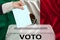 Male voter drops a ballot in a transparent ballot box against the background of the mexico national flag, concept of state