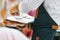 A male waiter hands holding plates and cutlery to set up a table, outdoors