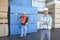 Male warehouse workers standing in front of stack of plywood