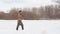 Male warm clothes walking on the field with hunting rifle.