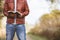 Male wearing a leather jacket standing on an empty road and reading bible with blurred background