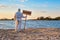 Male wearing protective suit stands with his back with warning sign in hand with inscription closed on beach