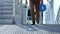 Male in white shirt and suit pants with high security bulletproof protect case climbs modern stairs outside the building