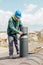 male worker with blue helmet installs an iron chimney.