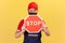Male worker in blue overalls red hat and t-shirt with facial protective mask holding stop traffic sign, prohibitions and
