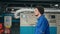 A male worker in a blue uniform walks through the workshop of a modern manufacturing enterprise. The automatic line