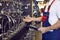 Male worker checks assortment on showcase with stainless steel water taps in plumbing store.