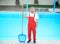 Male worker cleaning outdoor pool