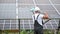 Male worker cleaning solar battery by mop.