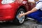 Male worker cleaning vehicle wheel with cloth