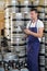 male worker holding digital tablet by barrels beer