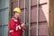 Male worker inspecting cargo container while writing on clipboard in shipping yard