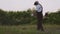 Male worker keeping electric trimmer and cutting grass