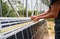 Male worker measuring solar panels with tape measure.