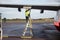 Male Worker Refueling Airplane While Standing On Step Ladder