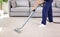 Male worker removing dirt from carpet