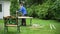 Male worker renewing old outdoor furniture bench. Man polishing wood boards