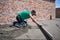 Male worker screeding floor at construction site.