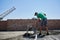 Male worker shoveling sand-cement mix at construction site.