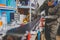 A male worker in a ski service workshop repairs the sliding surface of the skis. Close-up of a hand with a plastic scrapper for re